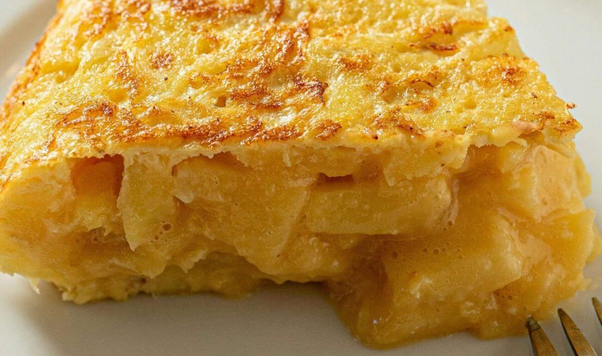 Spanische Tortilla Rezept- Aufgeschnittenes Stück spanischer Tortilla de Patata von oben gesehen – rustikal und hausgemacht.