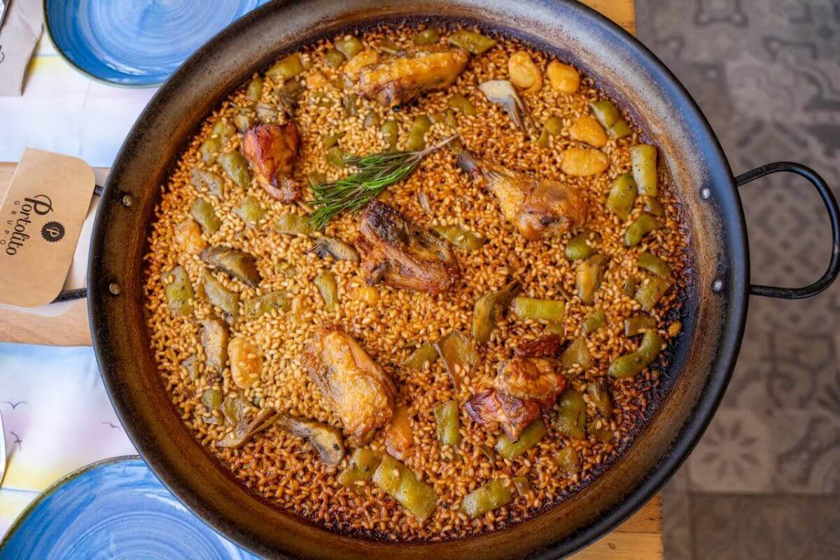 Spanisches Valenciana Paella Rezept serviert in typischer Paellera