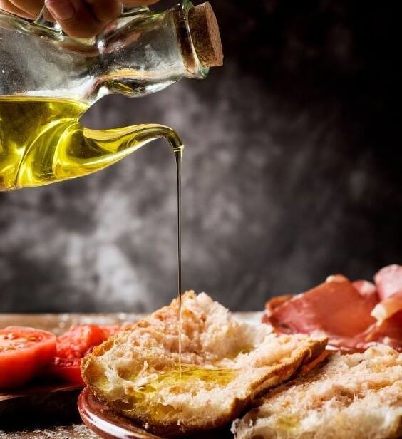 Spanisches Tomatenbrot (Pa amb Tomàquet) - Olivenöl wird über Pa amb tomàquet gegossen – klassisches spanisches Tomatenbrot
