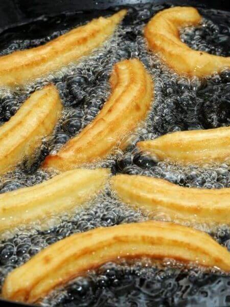 Churros Rezept Original in der Pfanne beim Frittieren, goldbraun und heiß