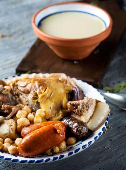 Cocido Madrileño seitlich serviert mit Fleisch, Wurst und Kichererbsen