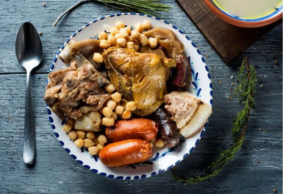Cocido Madrileño aus Kichererbsen, Fleisch und Wurst aus der Vogelperspektive