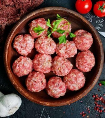 Rohe gesunde spanische Hackbällchen, bereit zum Kochen in Tomatensauce