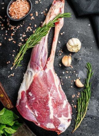 Lammkeule rezept -Rohe Lammkeule für ein spanisches Weihnachtsrezept, mit Knoblauch und Rosmarin vorbereitet