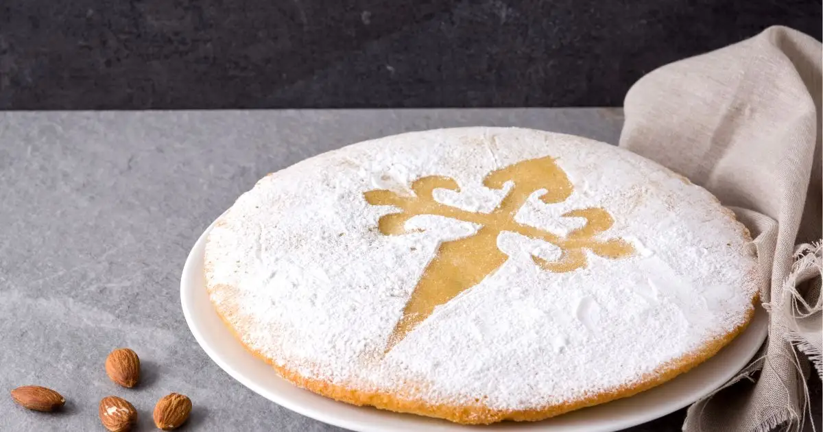 Tarta de Santiago Rezept von oben mit Puderzucker-Kreuz und Mandeln